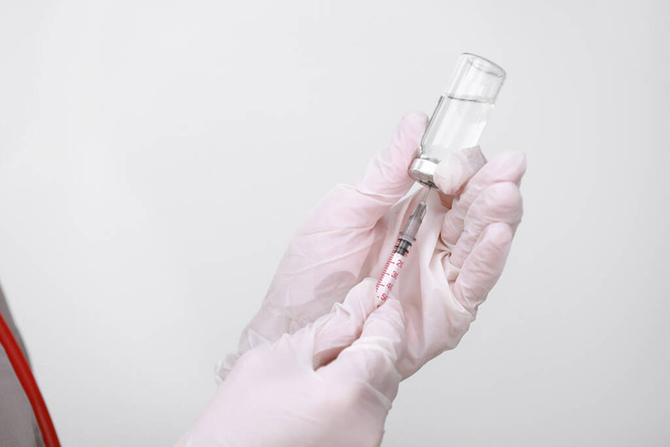 医師、看護師または科学者の手に白い医療手袋を保持インフルエンザ、はしか、コロナウイルスワクチンは、病気の流行の予防接種、薬と薬の概念のために撮影. - 写真・画像