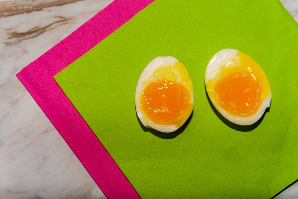 Hámozott lágy főtt tojás félbevágva, folyós sárgáját mutatva - Fotó, kép
