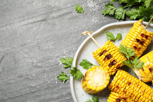 Delicious grilled corn cobs on grey table, flat lay. Space for text - Fotografie, Obrázek