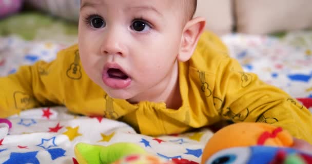 Säugling, Kindheitskonzept - Nahaufnahme eines lächelnden glücklichen Babys, das mit einem Beißring spielt. Zähne zusammenbeißen. Erste Zähne. Joy zahnlos 7 Monate Baby-Biss, nagt Beißspielzeug - Filmmaterial, Video