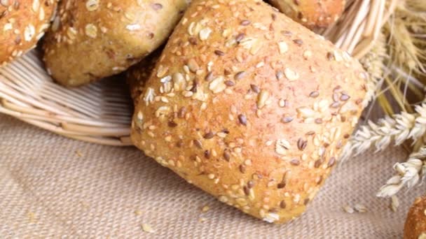 Bakery products. Rye bakery with crusty loaves and crumbs. Fresh loaf of rustic traditional bread with wheat grain ear or spike plant on natural cotton background. Concept - Cooking at Home - Footage, Video