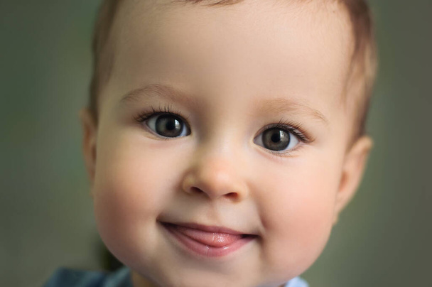 Bebé mostrando lengua. Chico sonriendo, de cerca. Emociones infantiles - Foto, Imagen