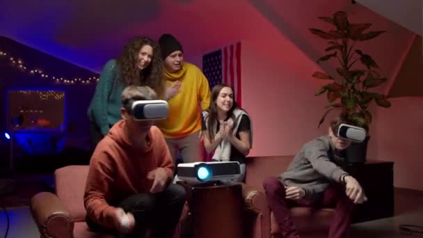 Ryhmä nuoria ystäviä pelaa virtuaalinen videopeli - Materiaali, video