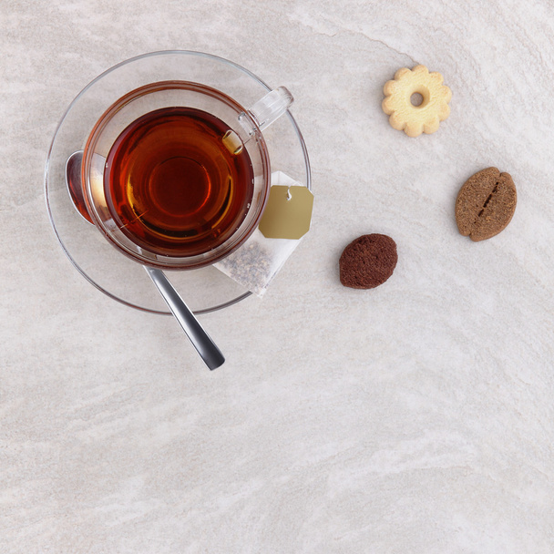 скляна чашка чаю з печивом на столі
  - Фото, зображення