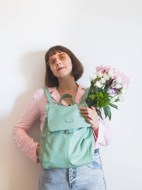 Young woman in pink with backpack and peony bouquet - Foto, immagini