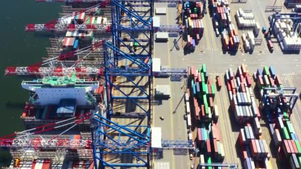 Containerschiffe im Export- und Importgeschäft und in der Logistik. Fracht wird per Kran in den Hafen verschifft. Wassertransport International. Luftaufnahme und Draufsicht. - Filmmaterial, Video