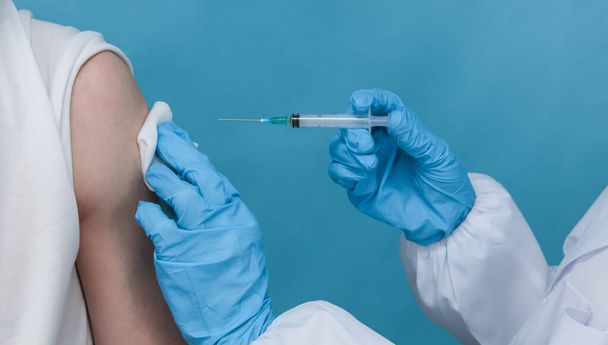 Doktor bir hastayı kolundan aşılar, yakından bakar.. - Fotoğraf, Görsel