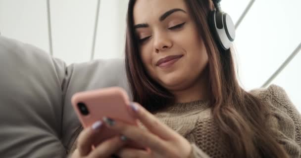 Frau hört Musik mit Handy und Kopfhörer - Filmmaterial, Video
