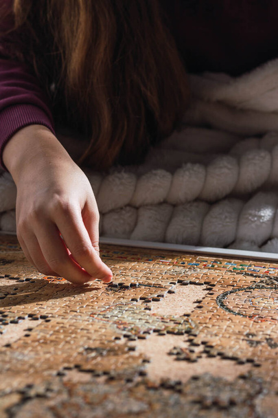 woman on the couch at home putting together a puzzle - 写真・画像