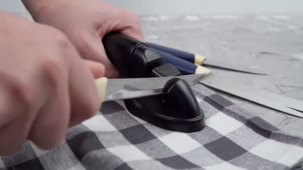 Mann schärft Küchenmesser manuell. Messerschärfen. Das Konzept der Pflege der Messerschärfe. - Filmmaterial, Video