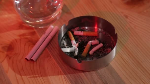 Mann in Bar steckt Zigarette in Aschenbecher und trinkt Wodka - Filmmaterial, Video