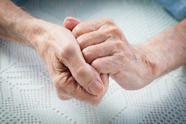 opieka jest w domu osoby w podeszłym wieku. starych ludzi, trzymając się za ręce. - Zdjęcie, obraz