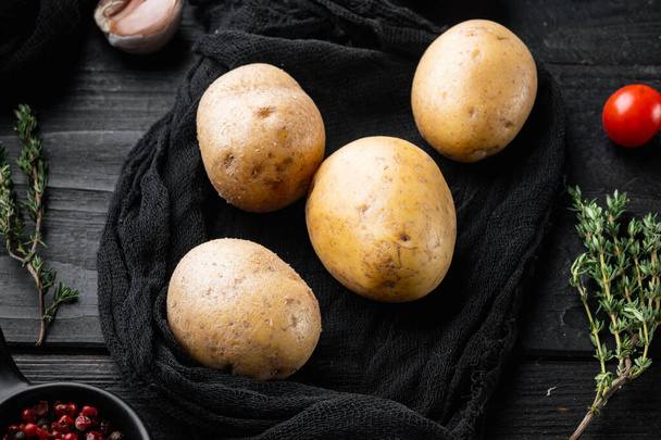 Conjunto de pila de patatas frescas, sobre fondo de mesa de madera negra - Foto, imagen