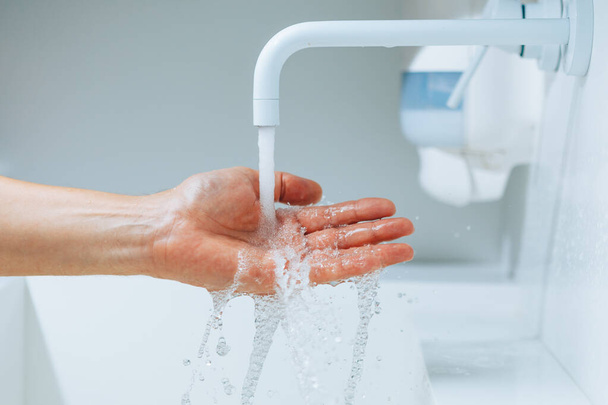 main sous le robinet avec éclaboussure d'eau courante - Photo, image