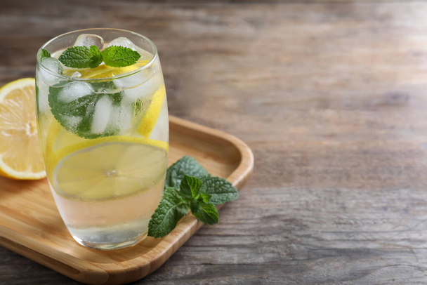 Delicious lemonade made with soda water and fresh ingredients on wooden table. Space for text - Foto, imagen