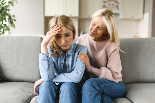 Worried mature mother consoles her adult daughter, helping with problem and depression, caring she, empathy, expressed maternal support. Support of a loved one - Photo, Image