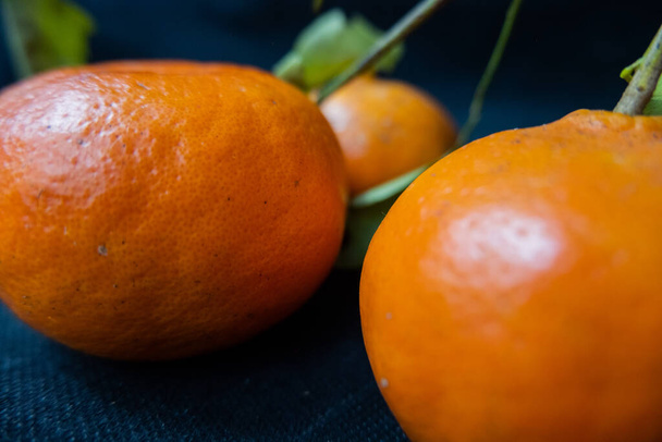 Tangerines isolated on a table with dark tablecloth - Foto, imagen