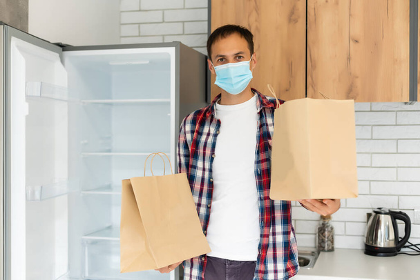 Delivery man holding paper bag with food, food delivery man in protective mask - Foto, Imagen