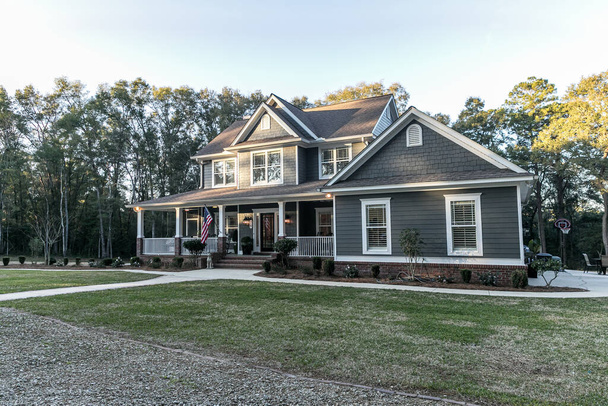 Front view of a large two story blue gray house with wood and vinyl siding - Photo, Image