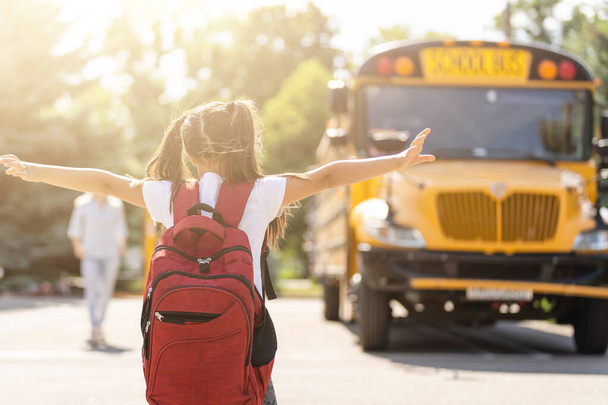 Anya elhozza a lányát az iskolába, közel az iskolabuszhoz. Vissza az iskolába. - Fotó, kép