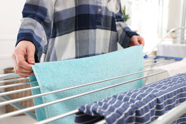Young woman hanging clean laundry on drying rack at home, closeup - Fotoğraf, Görsel
