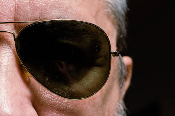 Lähikuva miehen silmästä, jolla on kultareunaiset lentäjän aurinkolasit, - Valokuva, kuva