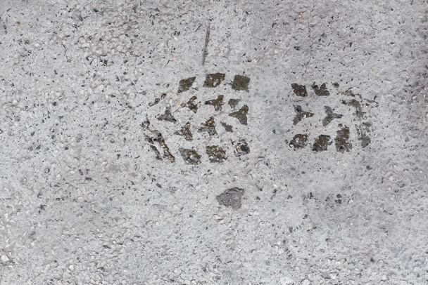 Wet shoe print on concrete cement white smooth surface with small pebbles aged urban texture in Sofia, Bulgaria, Eastern Europe - Photo, Image