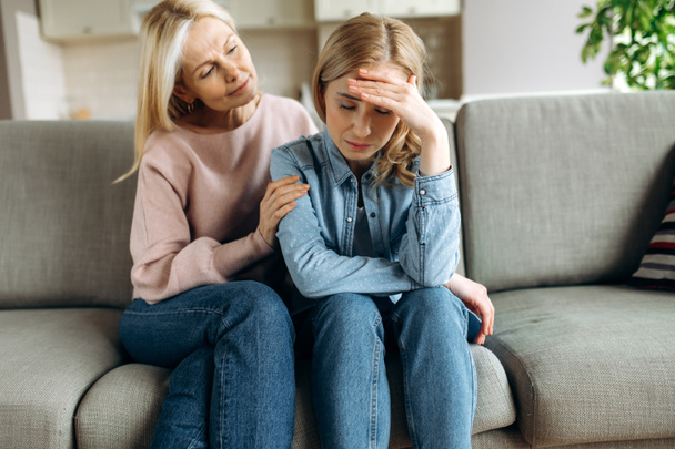 Worried mature mother consoles her adult daughter, helping with problem and depression, caring she, empathy, support in two age generations. Support of a loved one - Photo, Image