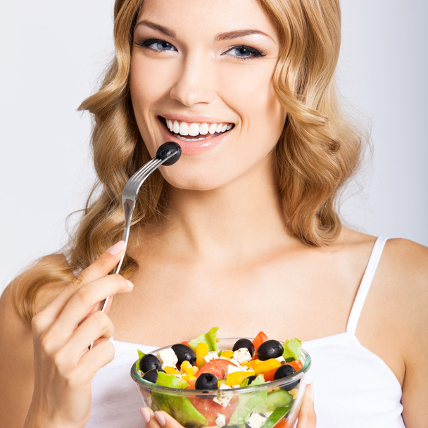 Mulher com salada vegetariana, sobre cinza
 - Foto, Imagem