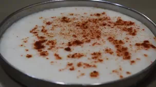 льется масло на белый дхокла также известный как хаман, блюдо Gujrati из белого теста и красный холодный масала на нем  - Кадры, видео