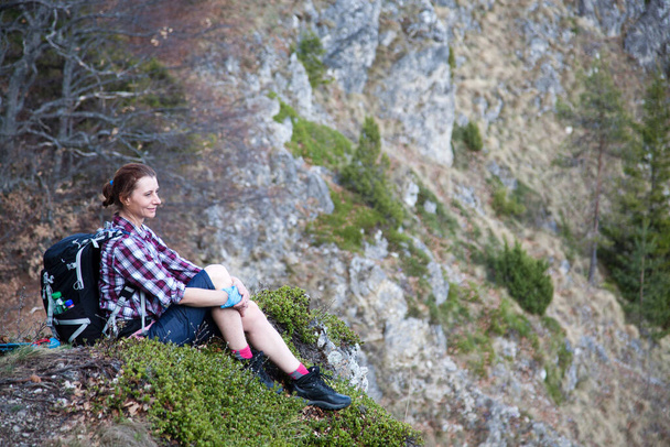 женщина-туристка сидит на вершине горы, любуясь видом - Фото, изображение