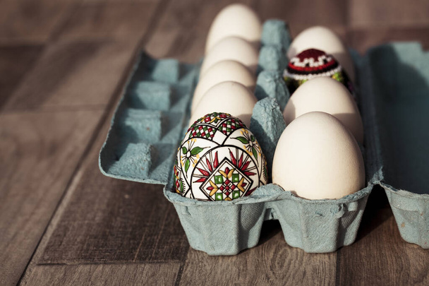 Білі яйця в коробці й традиційні пасхальні яйця з Буковини (Румунія). - Фото, зображення