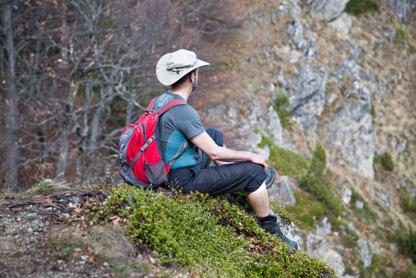 senderista sentado en la cima de una montaña admirando la vista - Foto, Imagen
