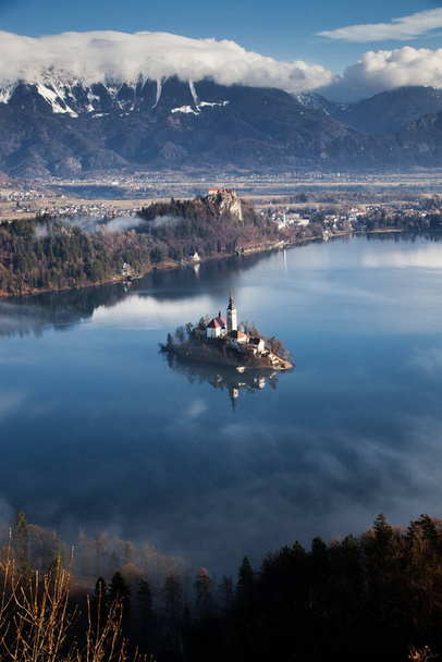 вид с воздуха на озеро Блед туманным утром с точки зрения Ойстрицы, Словения, Европа - фон для путешествий - Фото, изображение
