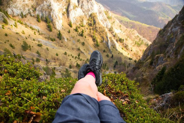 登山靴を履いた女性の足が山の上に座り - 写真・画像