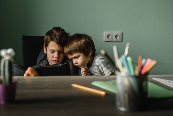 Niños jugando tableta en casa, creciendo con la tecnología - Foto, imagen