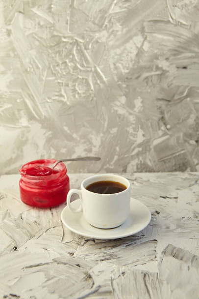 Een witte kop koffie op een grijze achtergrond. Het concept van warme drank. Koffiehuis, espresso, kopieerruimte - Foto, afbeelding