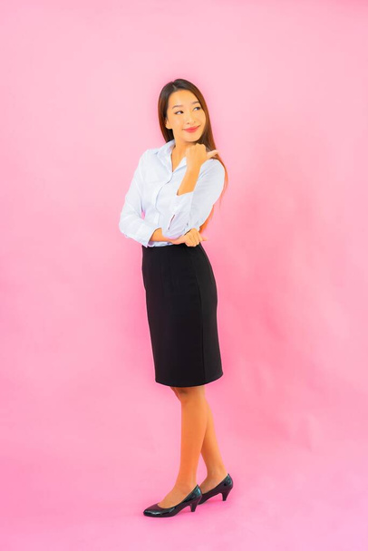 Portrait beautiful young business asian woman with action pink isolated background - Zdjęcie, obraz