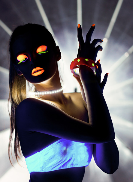 Disco girl with glow make-up dance in uv light - 写真・画像