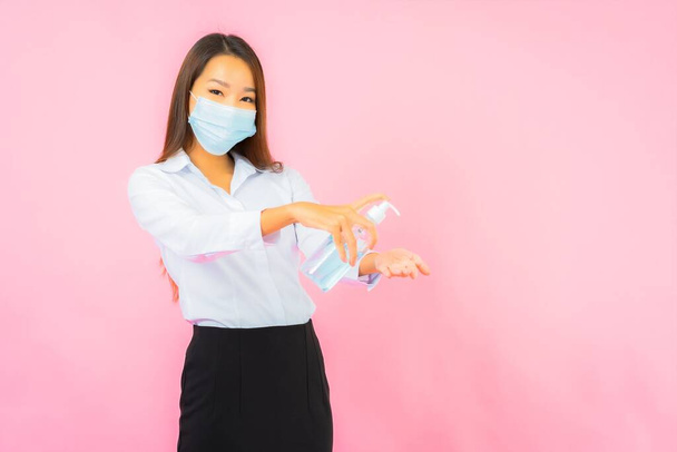 Portrait beautiful young asian woman wear mask for protect from covid19 and coronavirus on pink background - Photo, Image