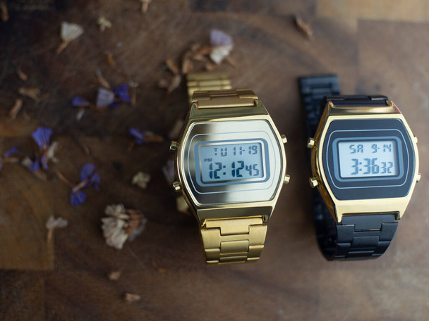 Zlaté hodinky a hodinky Černá nerezová ocel řemínek na pozadí z tmavého dřeva - Fotografie, Obrázek