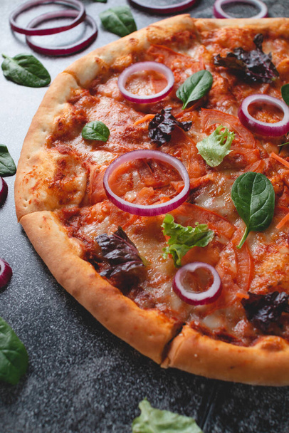 Tradycyjna włoska pizza pepperoni z cebulą, ziołami, pomidorami i serem na ciemnym tablicy - Zdjęcie, obraz