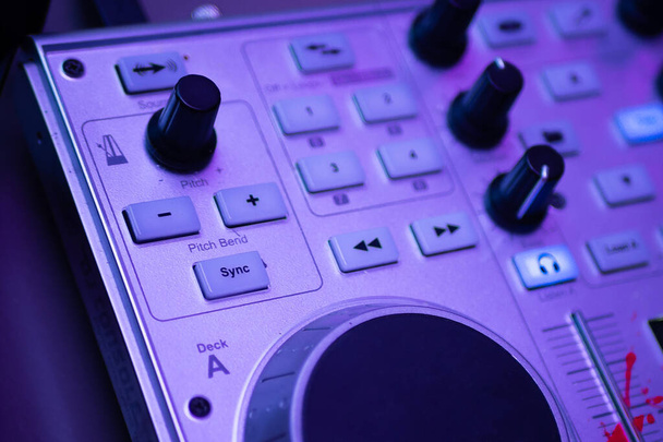 DJ воспроизводит и микширует музыку на цифровом контроллере midi. - Фото, изображение