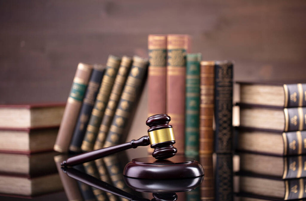 Rechtsthema. Richterkammer. Richtergabel, Maßstab und Sammlung von Rechtsbüchern auf dem braunen Schreibtisch und dem braunen Hintergrund. - Foto, Bild