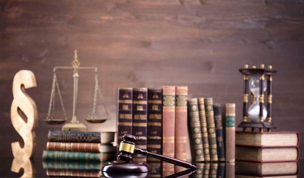 Thème droit. Chambre du juge. Juges marteau, échelle et collection de livres juridiques sur le bureau brun et le fond brun. - Photo, image