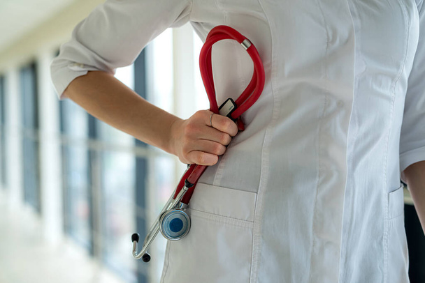 Kobieta lekarz trzymający stetoskop w rękach w klinice - Zdjęcie, obraz