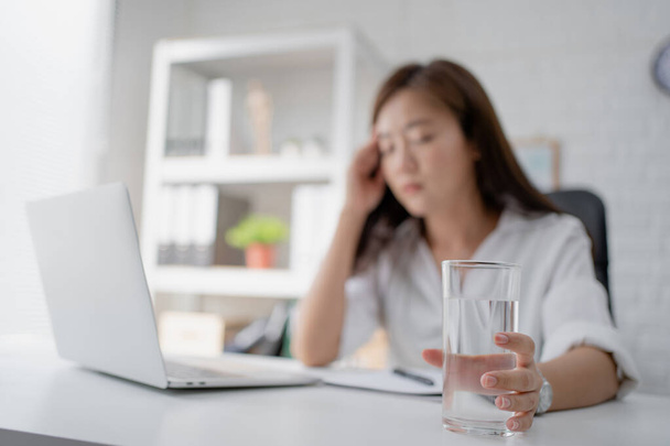 Business woman drink water. She felt like she was sick in the office. - Фото, изображение