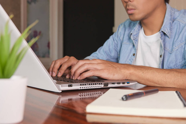 Zoom Hand of Asian Casual Businessman in Denim or Jeans Shirt Typing Laptop in Coffee Shop. Nenáročný podnikatel s technologií - Fotografie, Obrázek