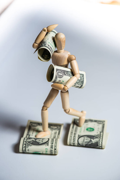 figura de brinquedo homem de madeira com dinheiro no fundo branco. Conceito de negócio. - Foto, Imagem