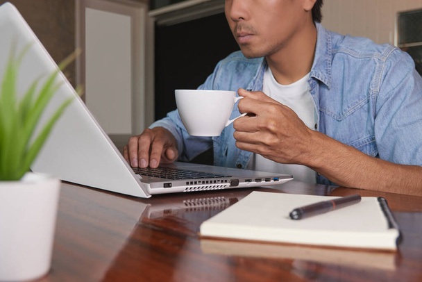 Denim 'de Zoom View İş Adamı ya da Kotlu Tişört Giyen Laptop ve Kahve Fincanı Kullanıyor. Teknolojide Gündelik İşadamı - Fotoğraf, Görsel